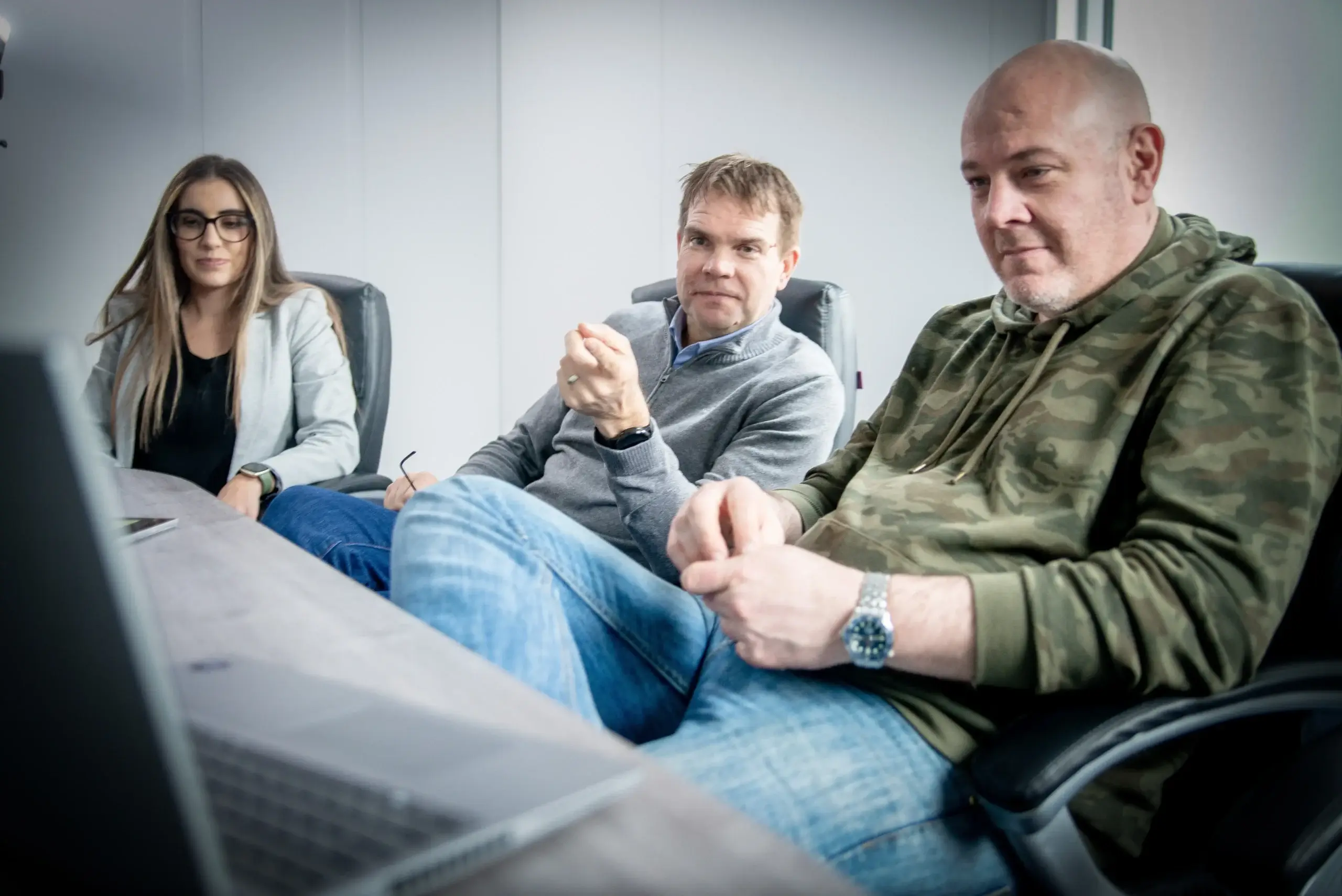 Three people in a room discussing HSSEQ of subsea offshore connectors