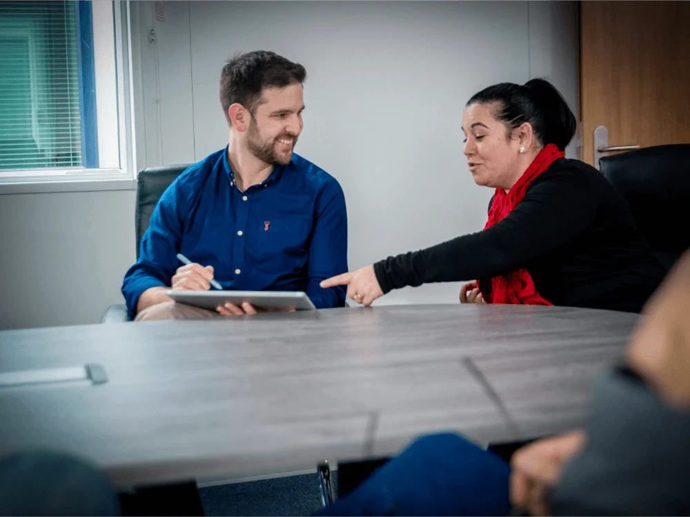 Collaborating Engineering career workers sat down at desk discussing offshore wind, decommissioning, and oil & gas connectors, mooring and subsea quick-connect tools